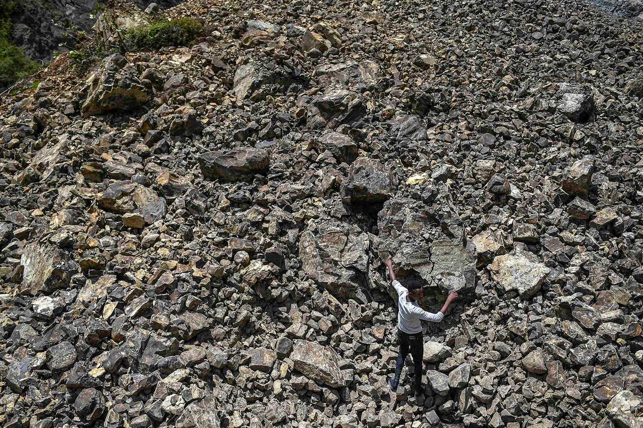 A man walks over rubble that covered a road during a landslide triggered by the earthquake in River Glass, Haiti, Aug. 18.