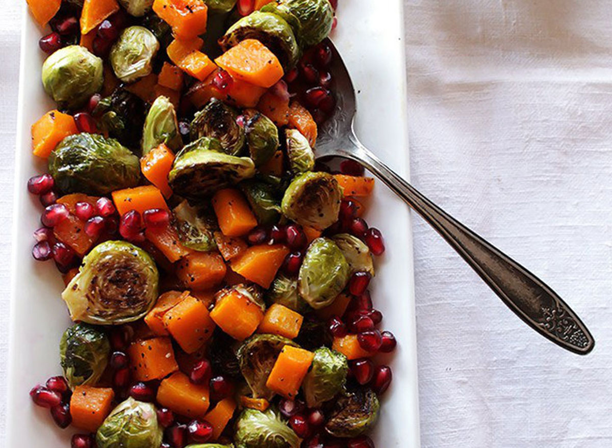 Roasted brussels sprouts with butternut squash and pomegranates on a plate ready to be served