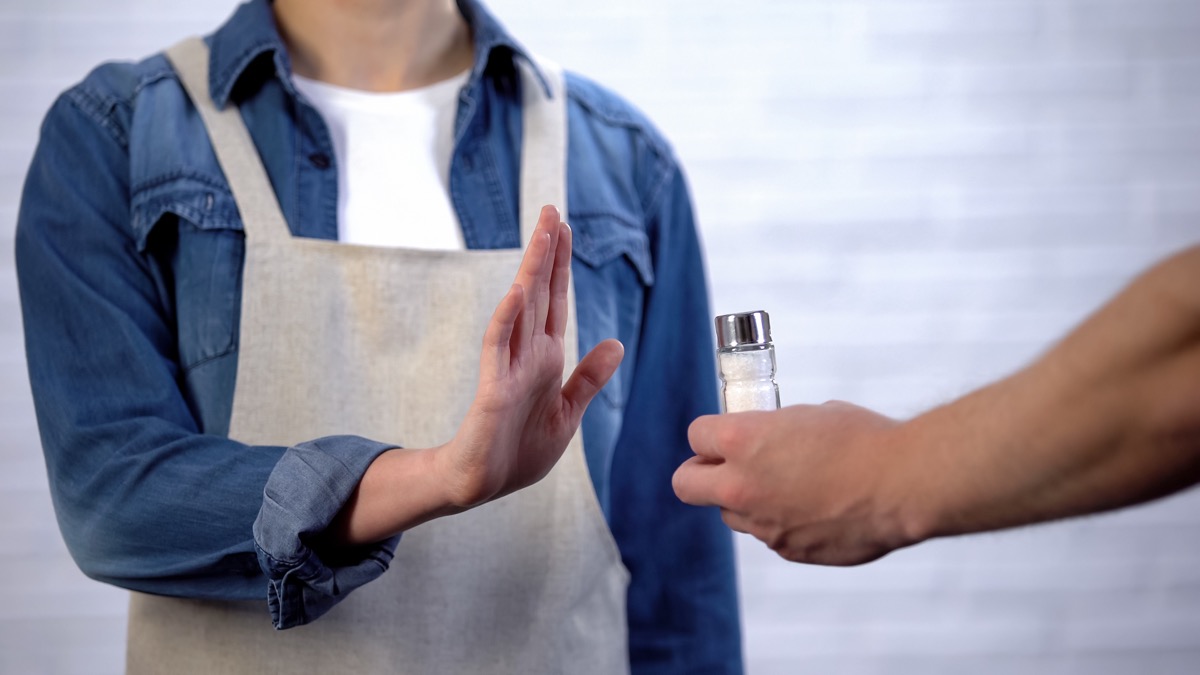 Chef refusing salt in cooking, healthy nutrition to prevent heart disease
