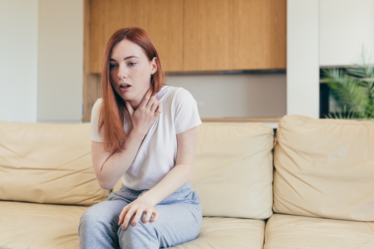 Woman suffering an anxiety sitting on a couch.