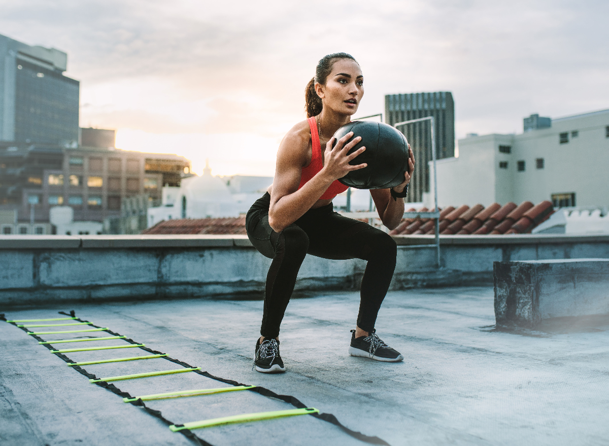 woman squats with medicine ball