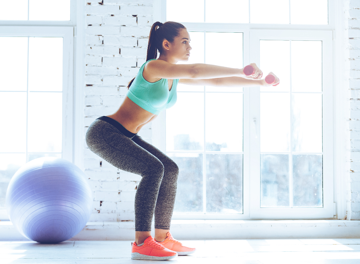 woman does squat with dumbbells