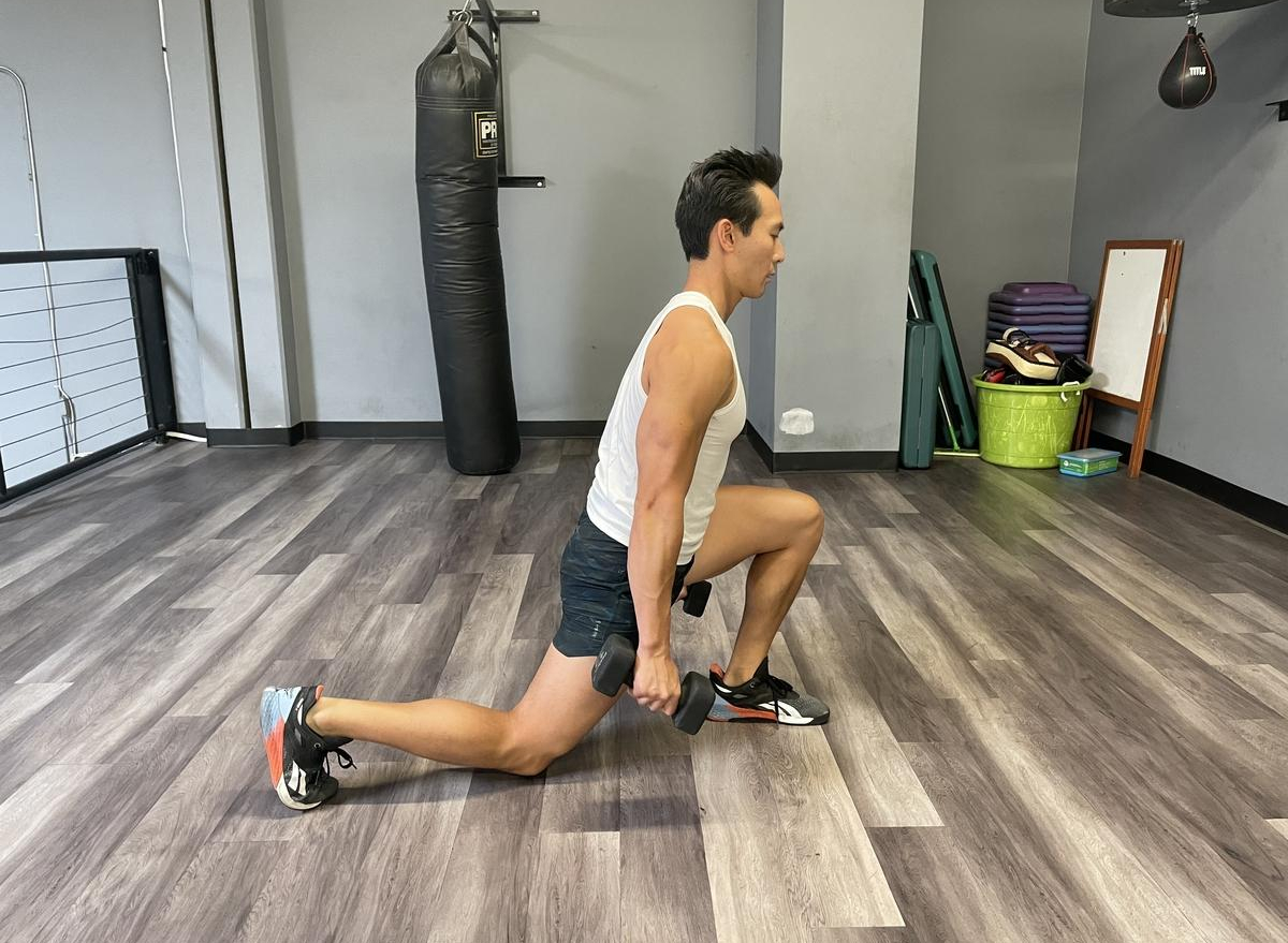 trainer doing dumbbell split squats