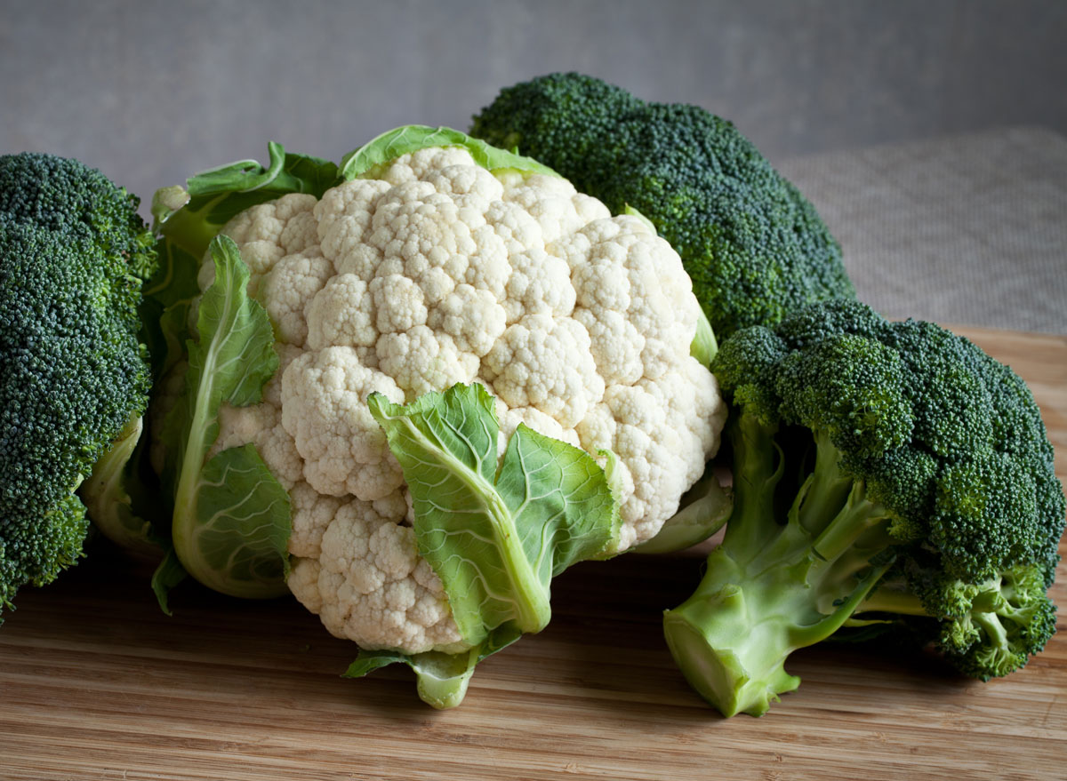 Cruciferous vegetables broccoli cauliflower on wooden cutting board