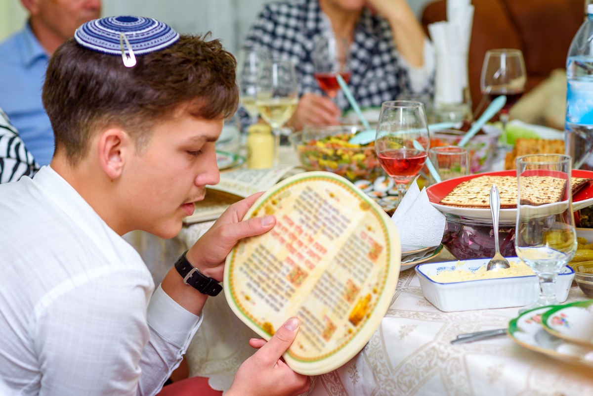 Jewish family celebrate Passover Seder reading the Haggadah