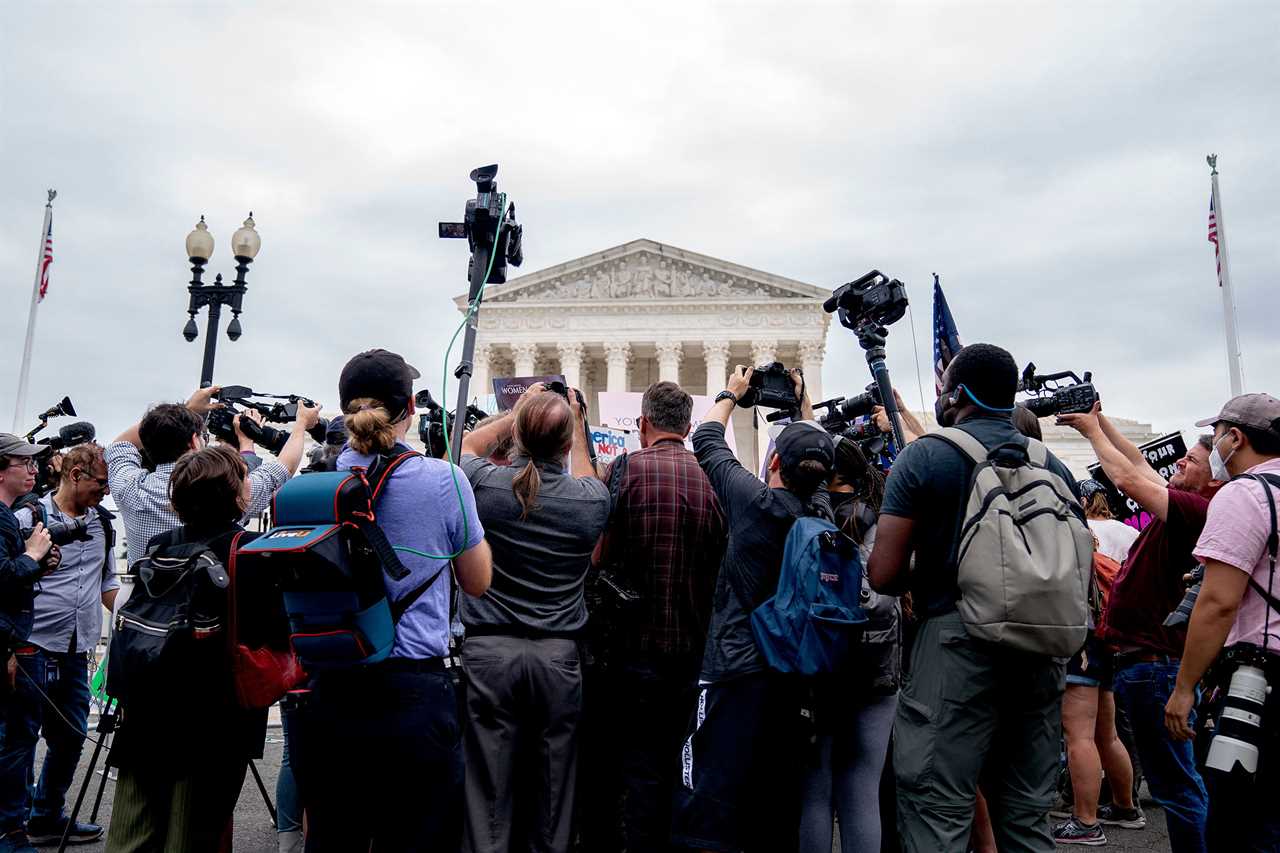 Members of the media gather around anti-abortion and abortion activists demonstrating outside the Supreme Court in Washington, on June 21, 2022.