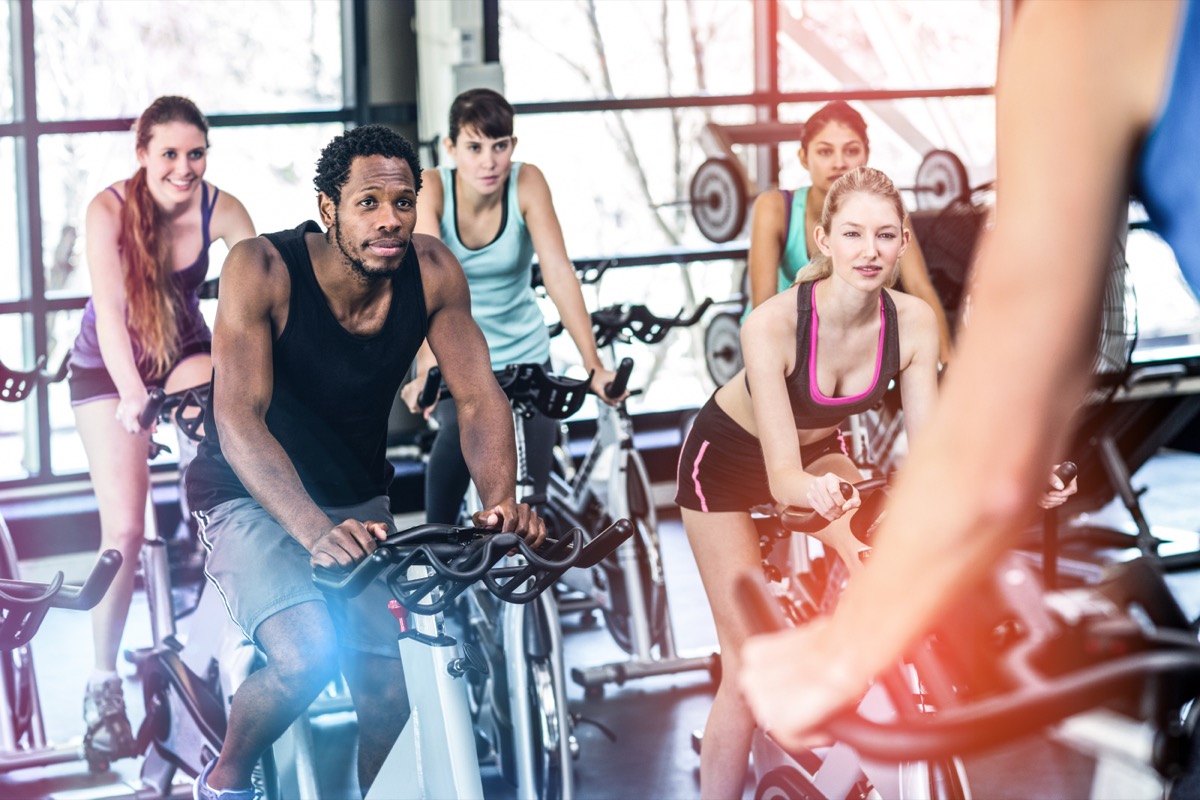 multiracial group of 20 or 30-something adults on bikes in an indoor cycling class