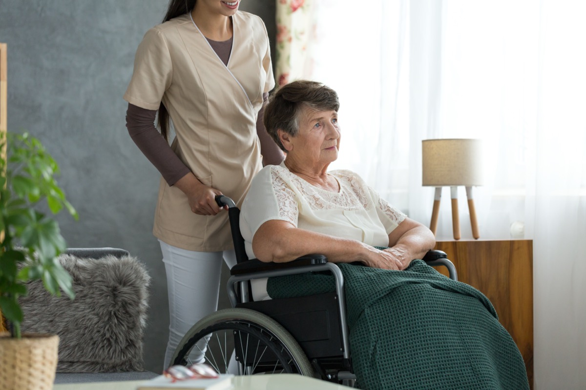 Senior lady with alzheimer's disease, sitting in a wheelchair, confused about where she is