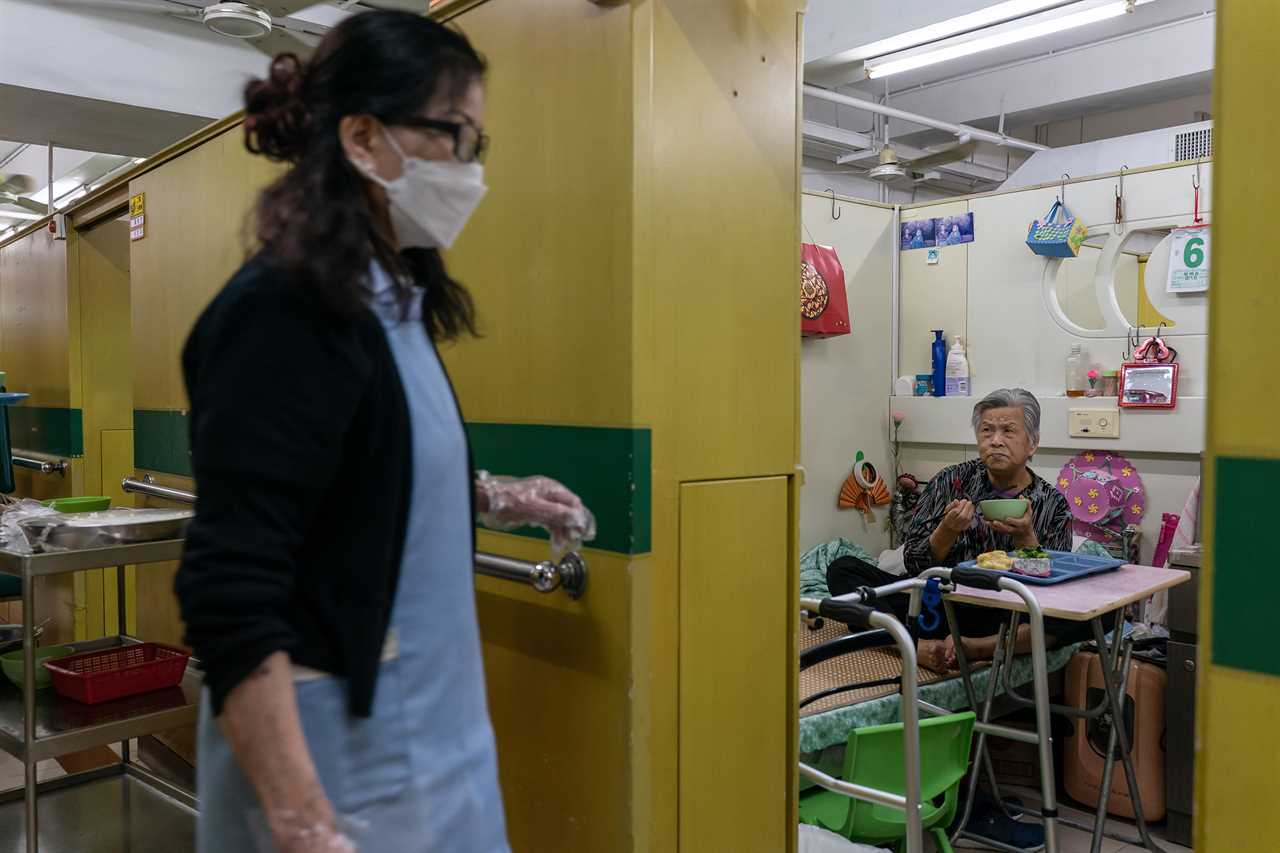 Yip Fung Cheung, 82, a resident of Kei Tak (Tai Hang) Home For The Aged, eats dinner in her living cubicle.