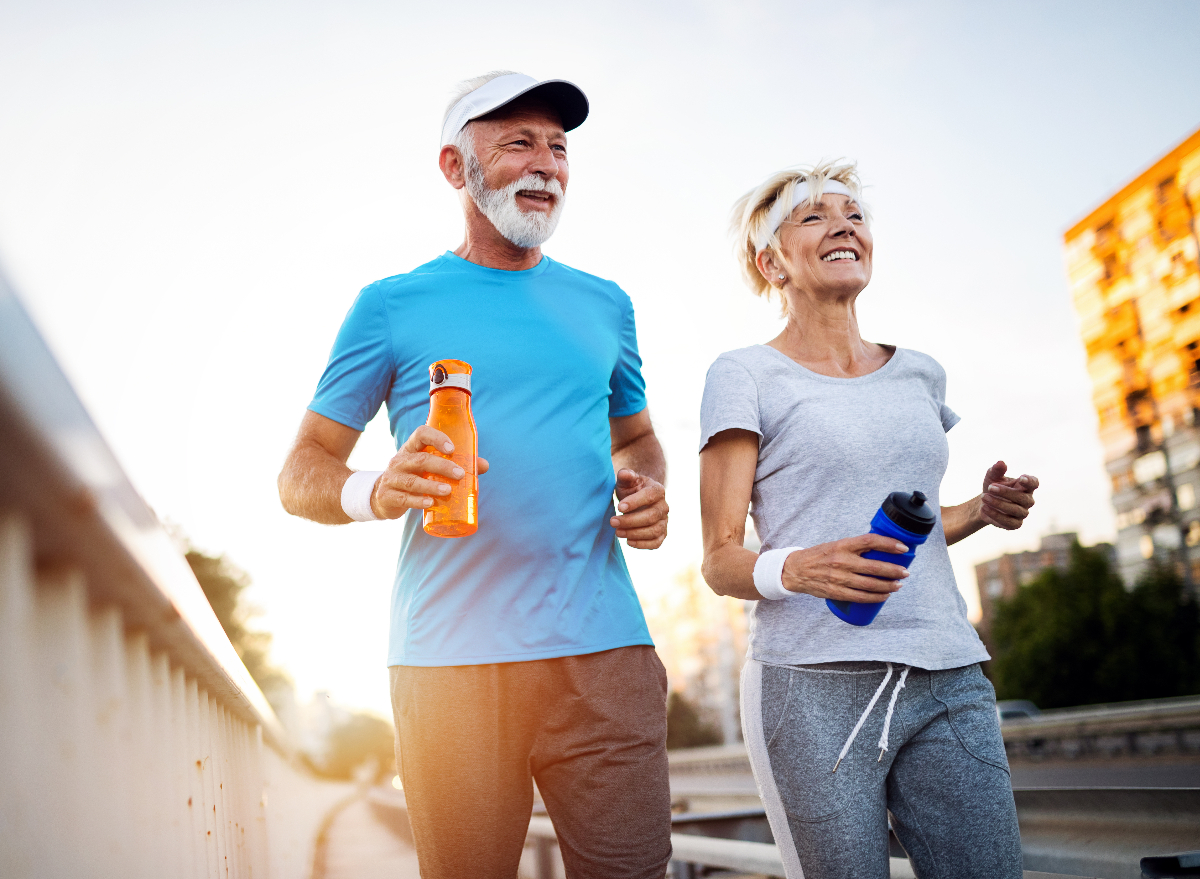 older active couple running outside