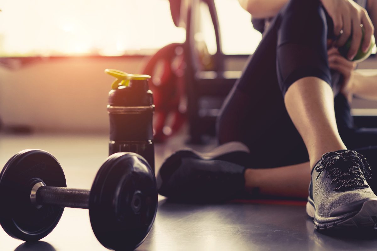 woman sitting with dumbbell at gym