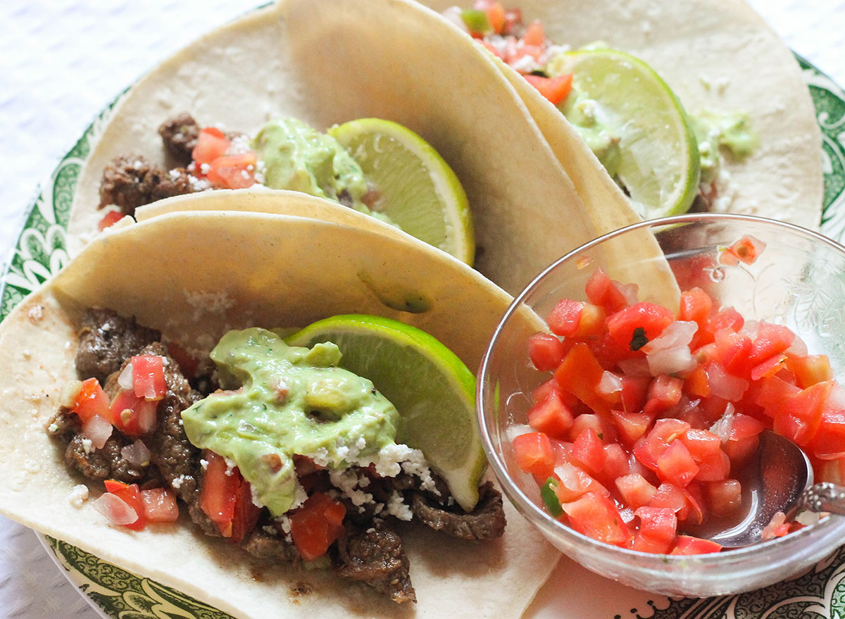 Steak tacos with toppings on a plate.