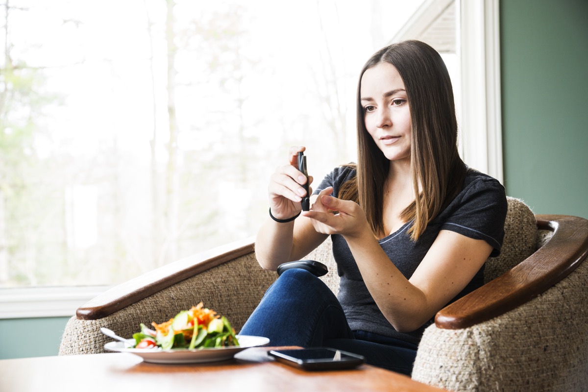 Young diabetic woman checking her blood sugar levels.