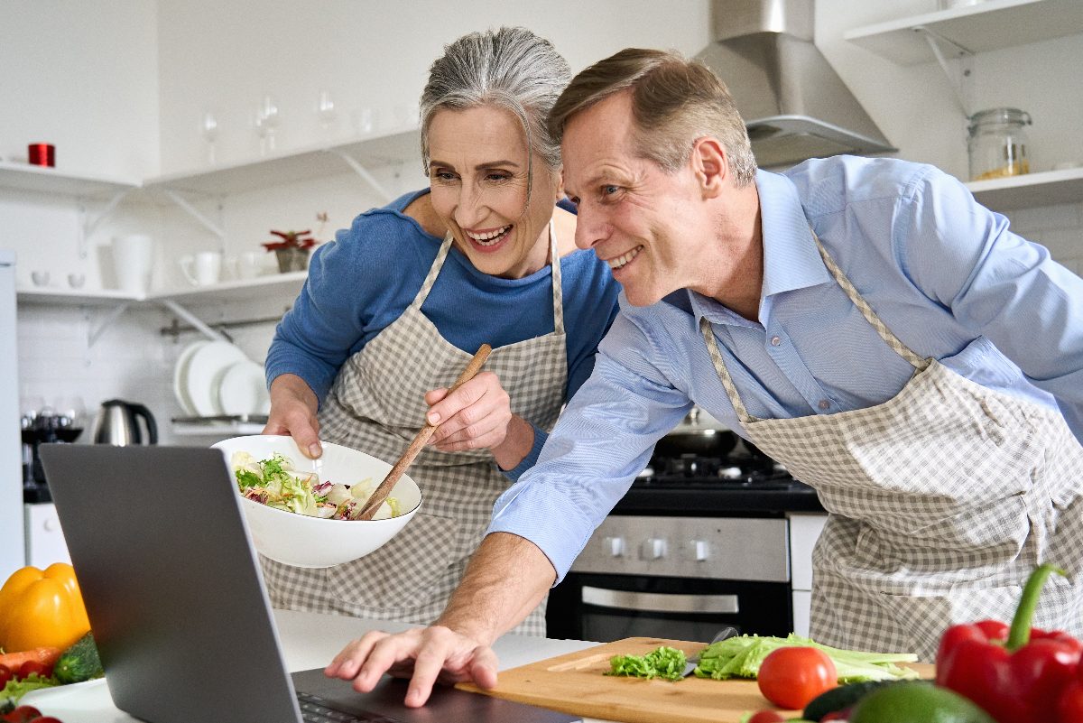 mature couple cooking a healthy meal for slimming down after 60