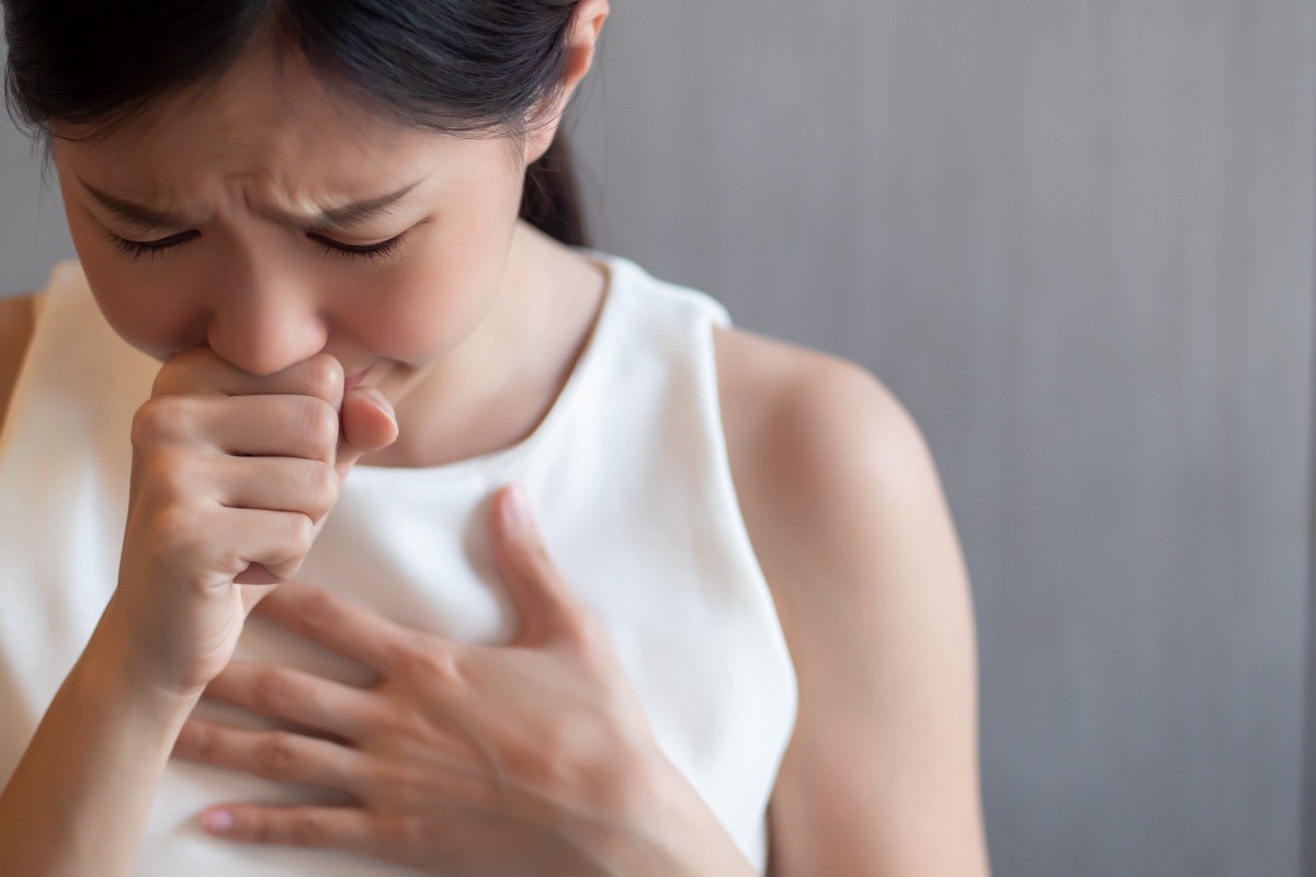 Sick woman coughing, experiencing hiccup.