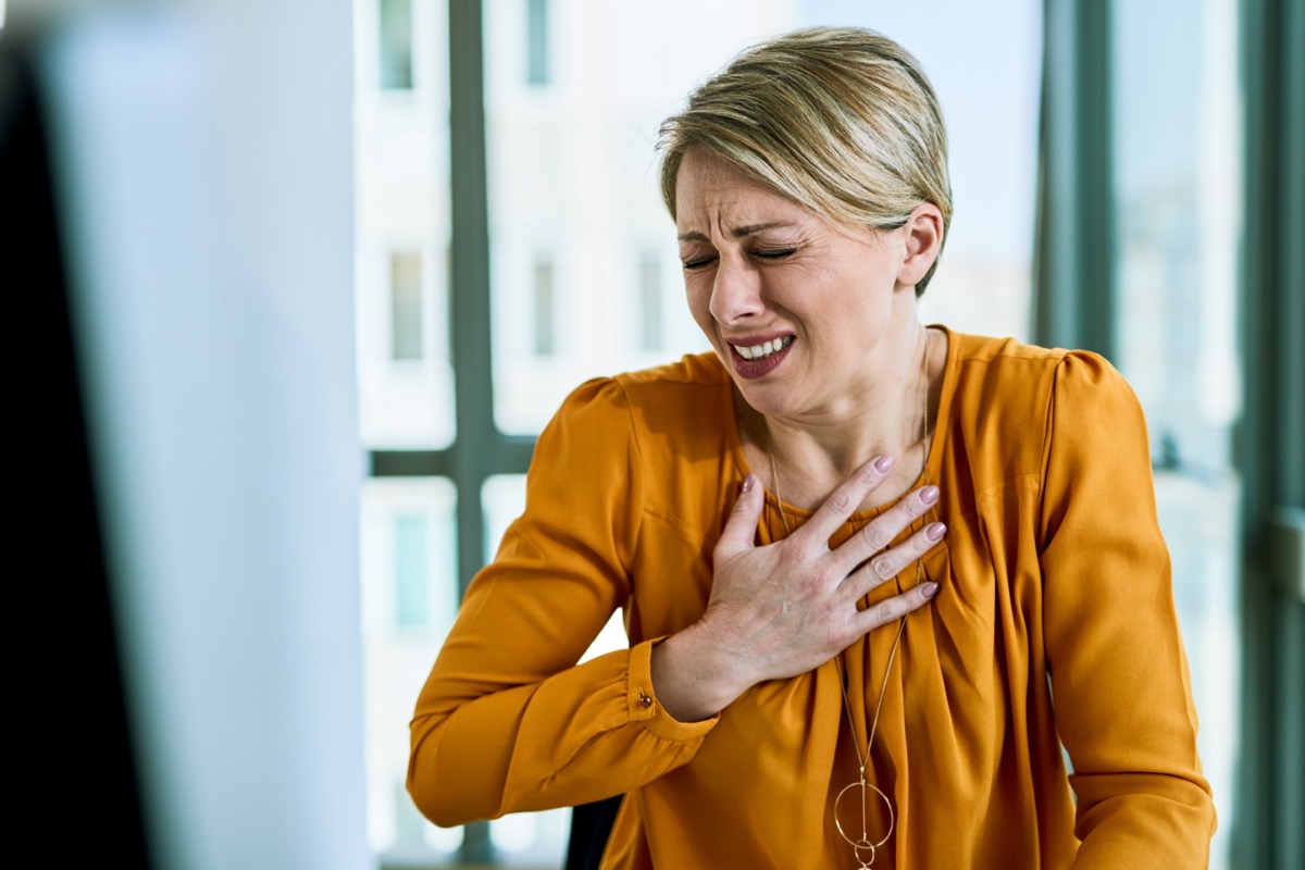 Businesswoman feeling chest pain while working in the office.