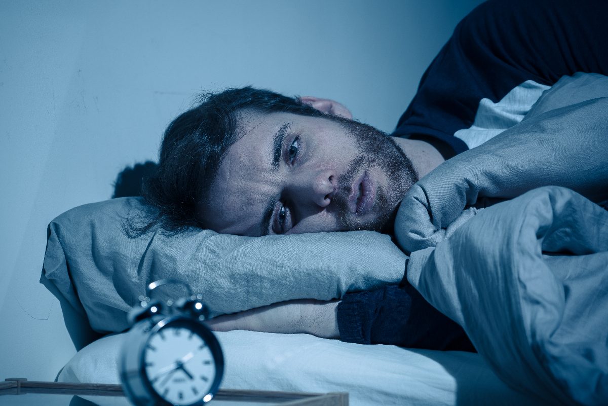 man stressed in bed that he can't sleep