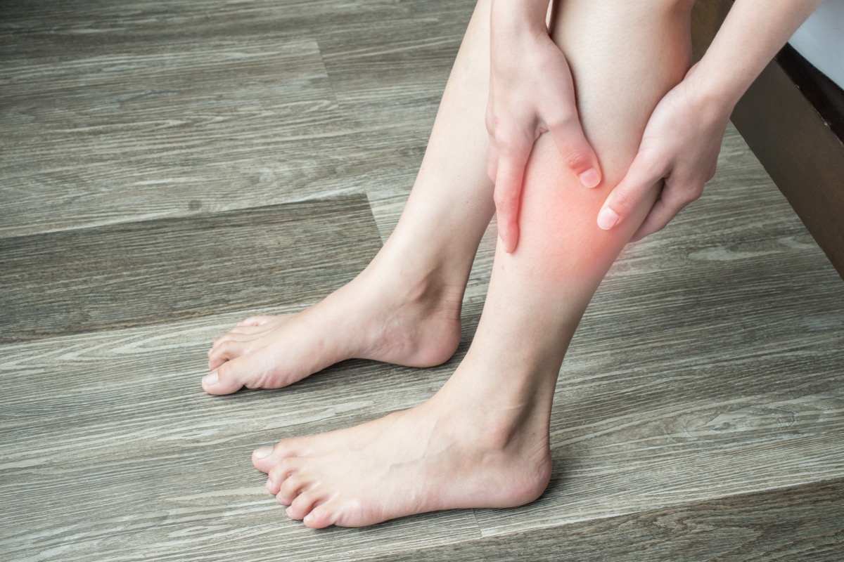 woman hands holding and massage her calf, suffering from calf pain