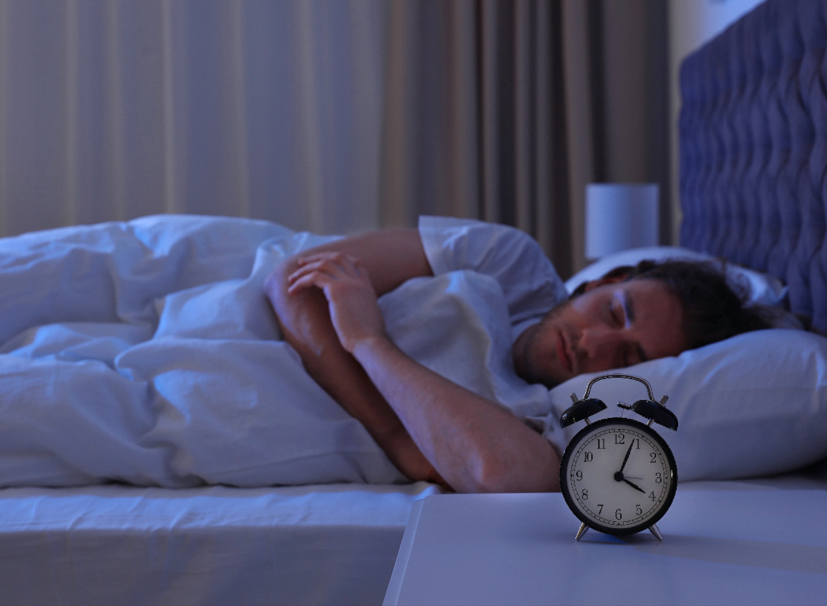 man sleeping peacefully in dark bedroom