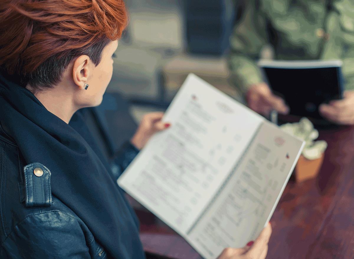 woman looking over menu outside
