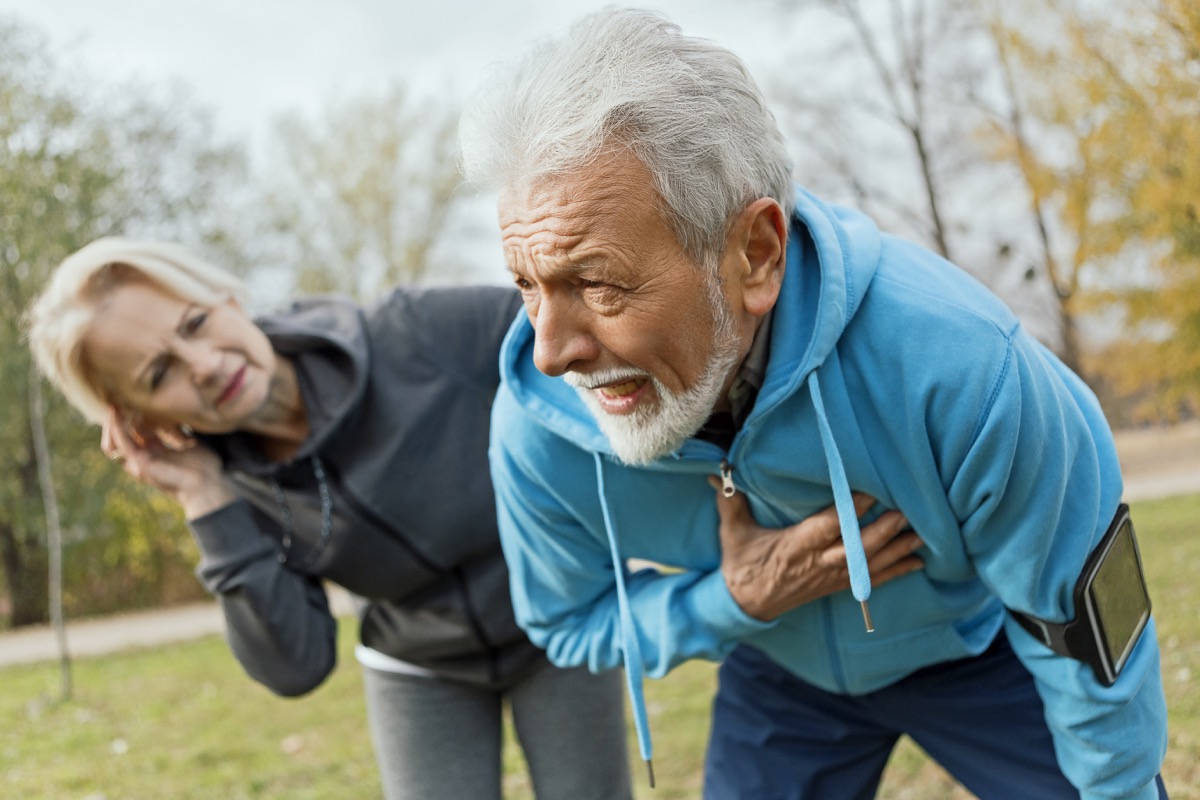 Senior man suffering heart attack while jogging with wife.