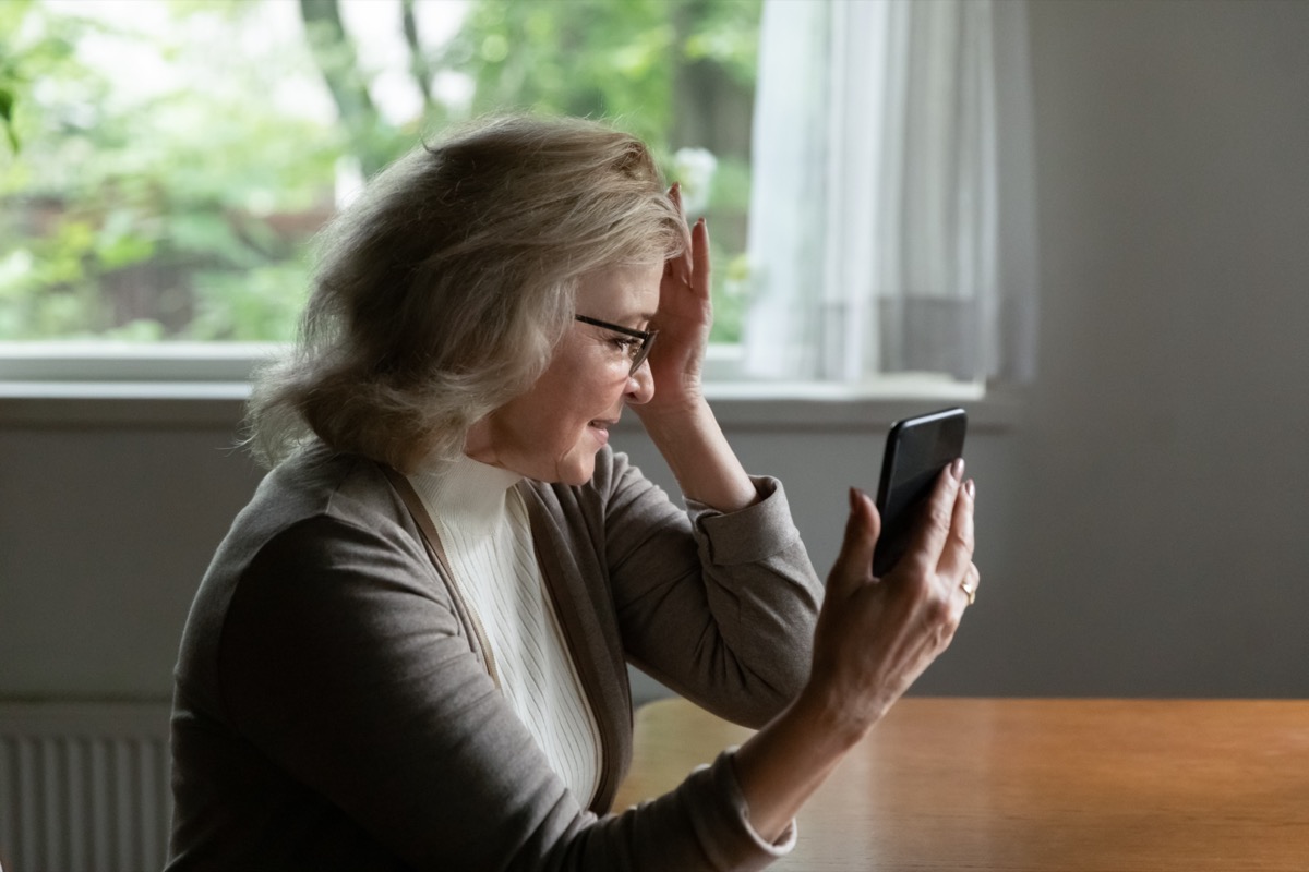 Pensioner reading message on mobile phone