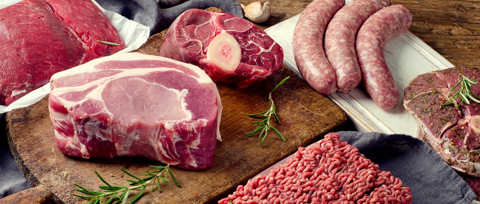 Different types of fresh raw meat on dark wooden background.