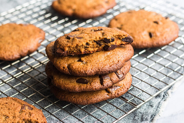 Keto Chocolate Chip Cookies stacked on a cooling rack