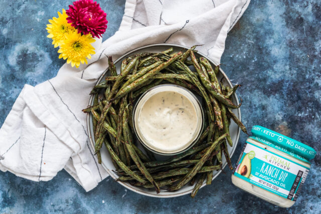 Plate of air fried green beans, Primal Kitchen Ranch Dip, white kitchen towel, fresh flowers.