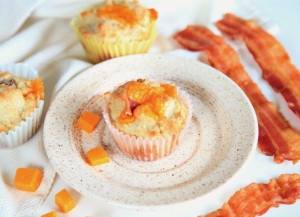 Plate with bacon cheddar muffins and several strips of bacon.