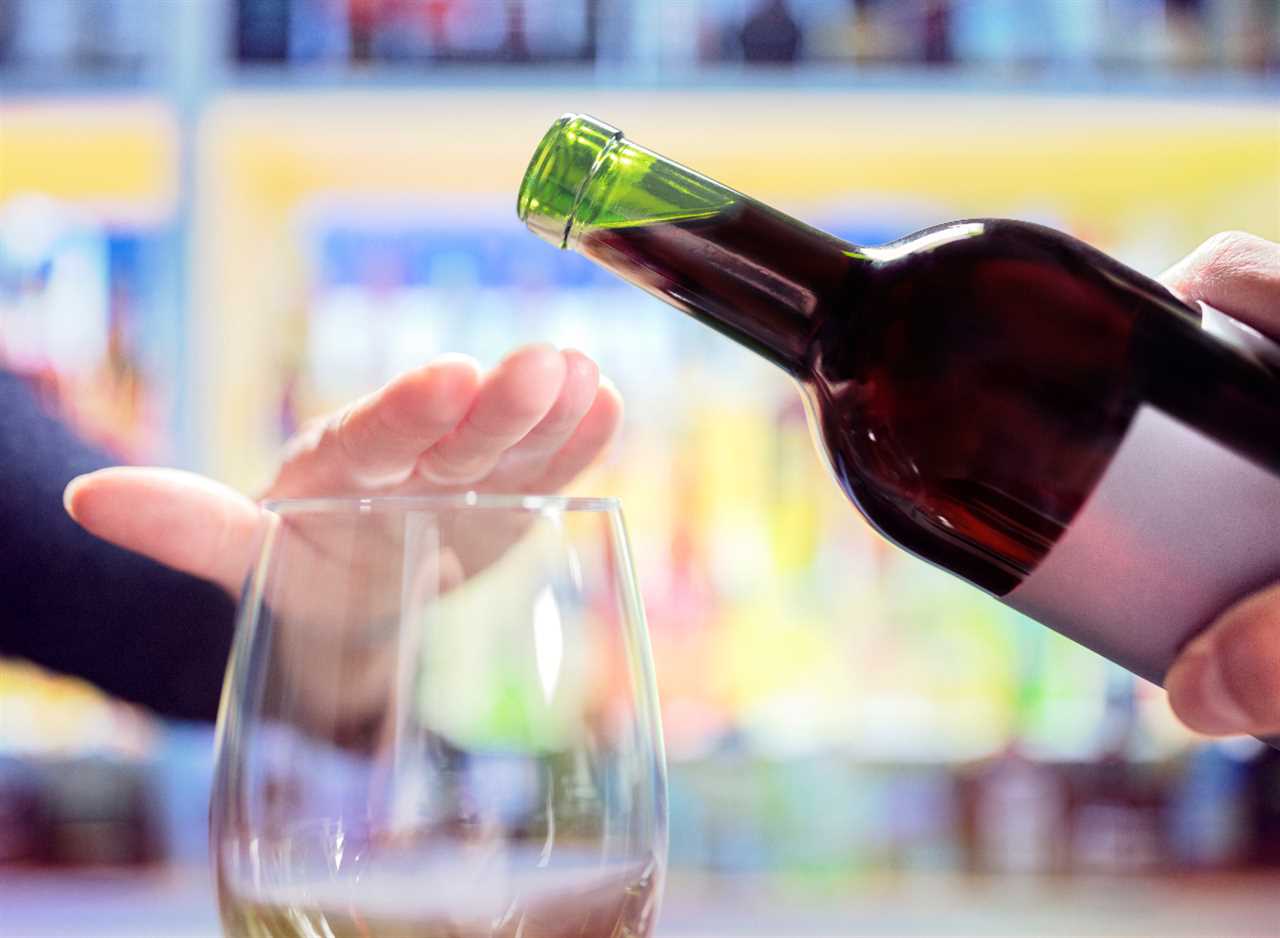 woman refusing more alcohol, wine bottle