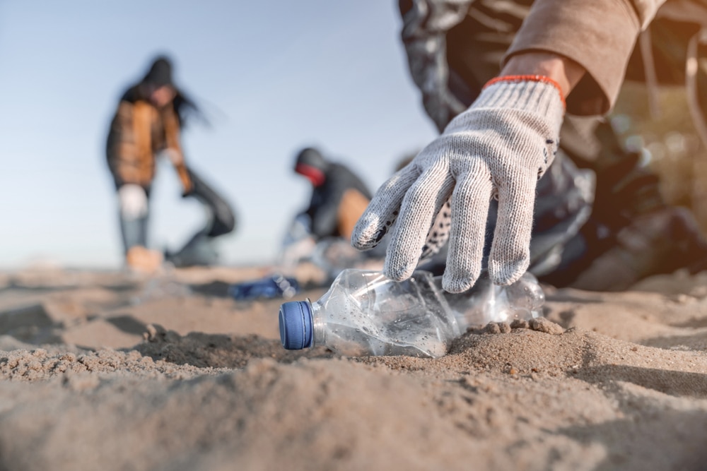 A volunteer collecting trash on the beach.