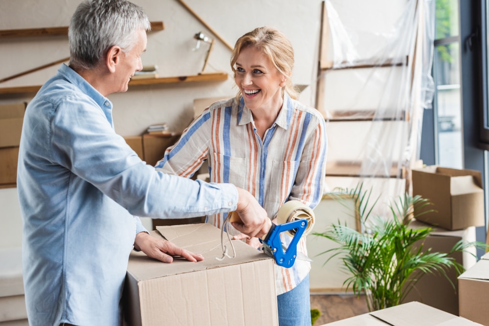 An older couple packing moving boxes.