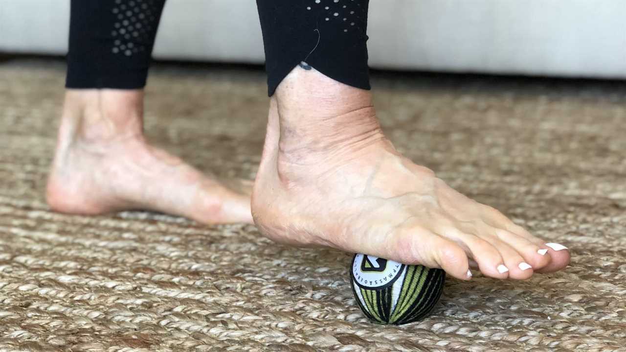 Close-up of foot rolling a massage ball underneath