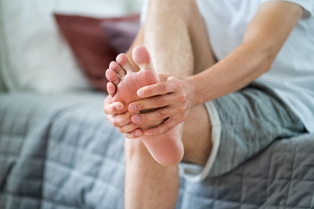 man rubbing his feet