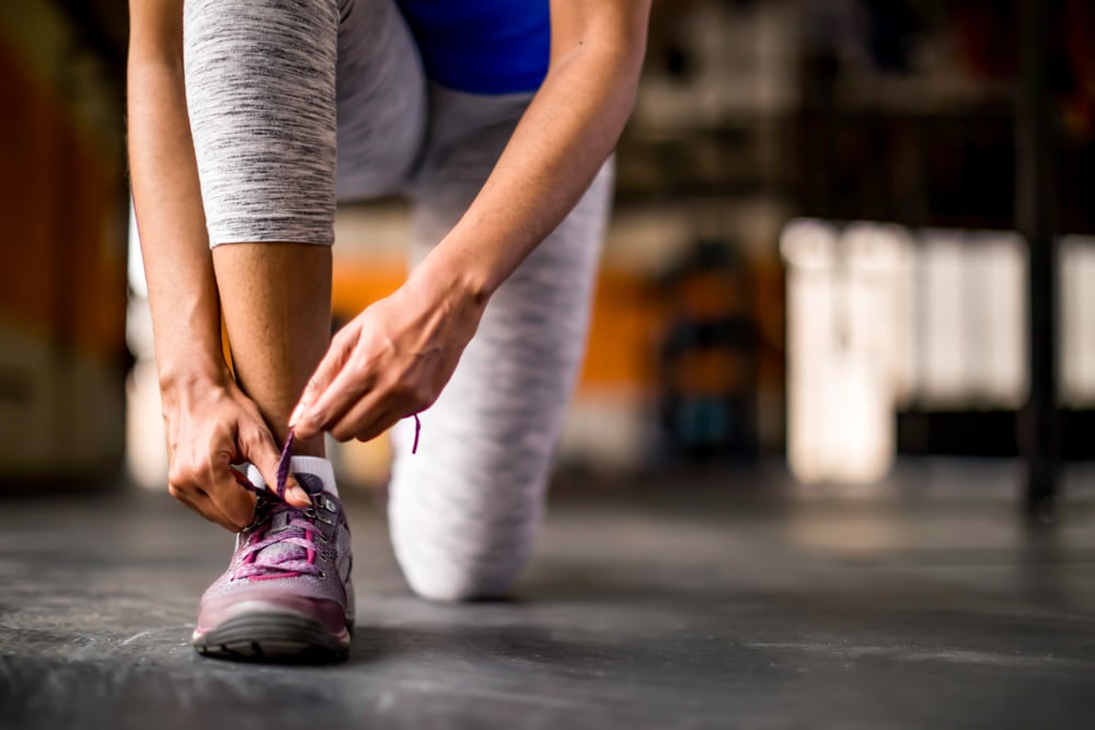 A woman tying her shoe.