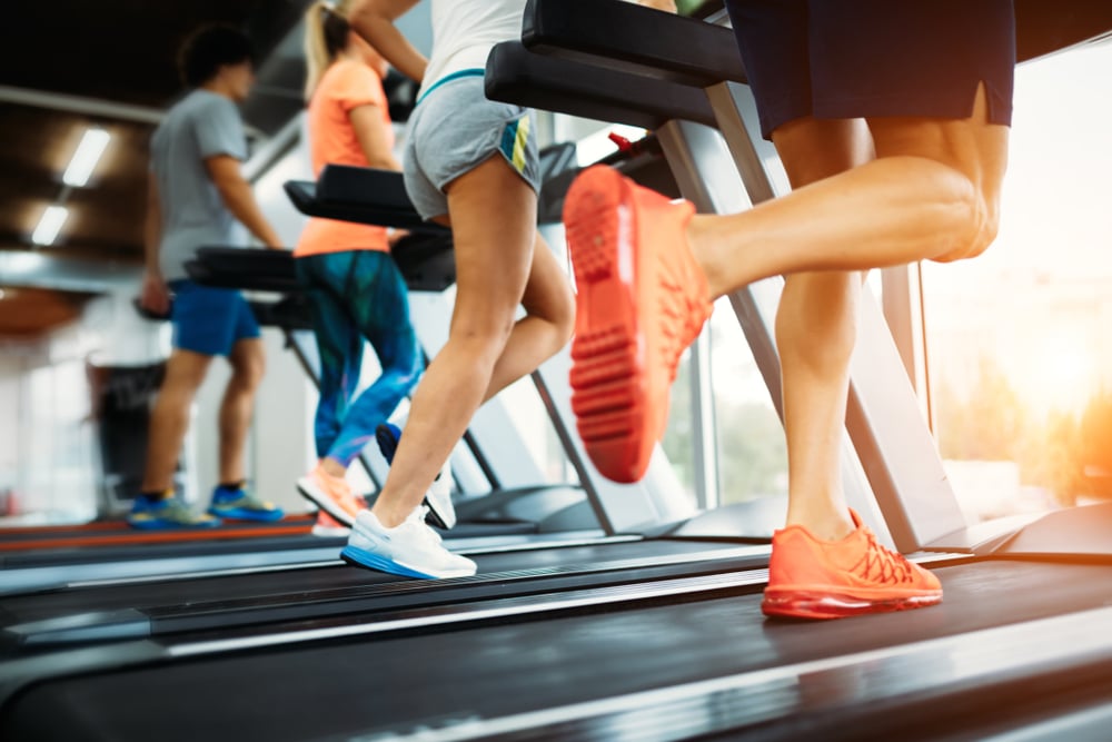 Close up of different people running on treadmills. 