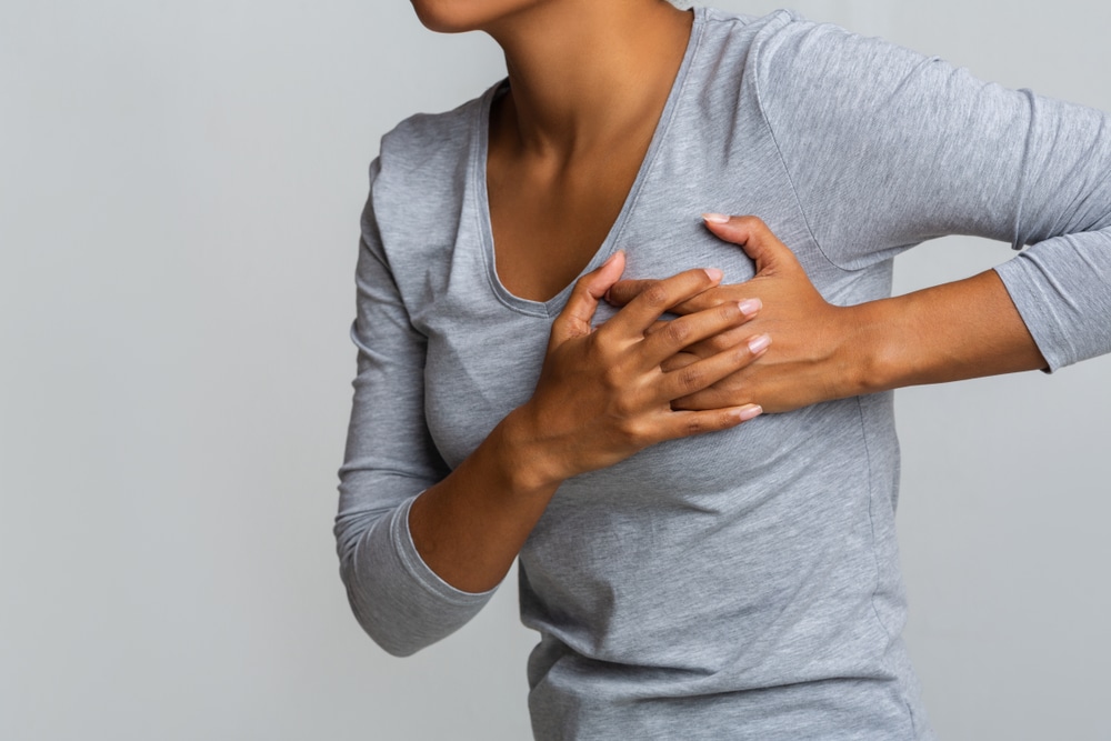 Woman holding her sore breast.